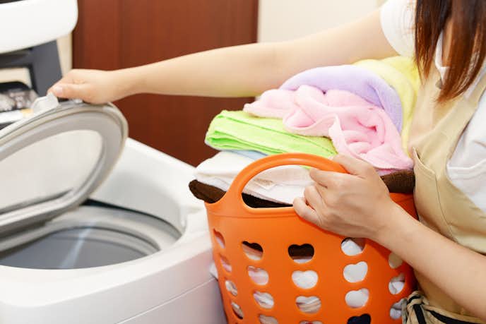 縦型洗濯機で洗濯物を洗った女性