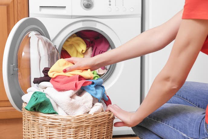 乾燥機付きの洗濯機で衣類を洗う人
