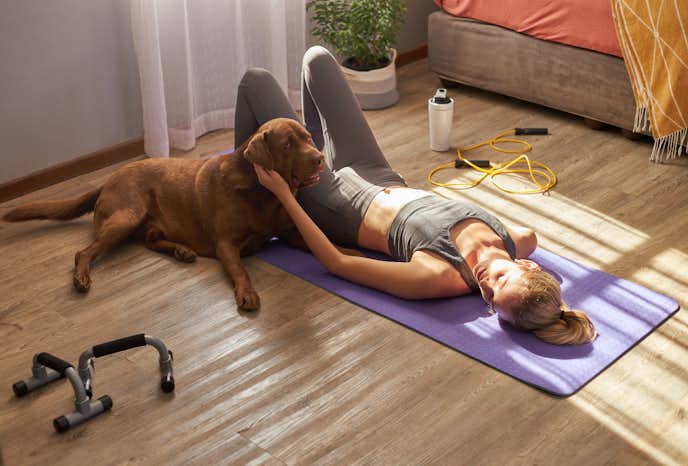 自宅で犬と一緒にトレーニングをしている女性