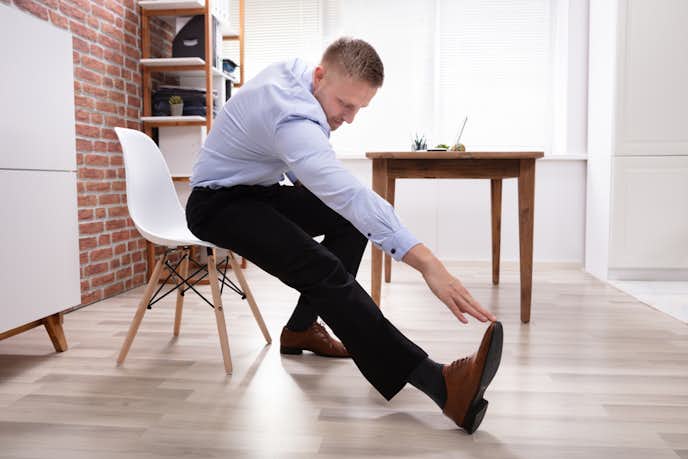 オフィスでハムストリングのストレッチをする人