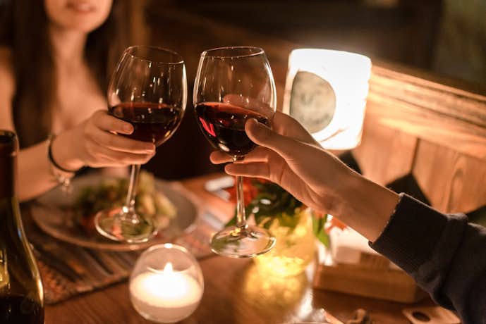 食事デートをしている男女がワインを飲んでいる写真